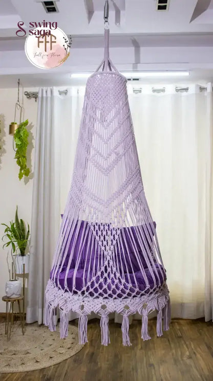 hanging macrame chair swing in purple color with mattress and cushions.