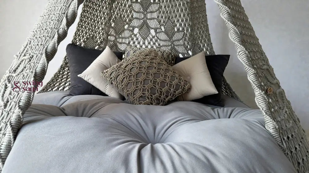 Macrame hanging swing in grey color with macrame cushions and square shaped cushions.