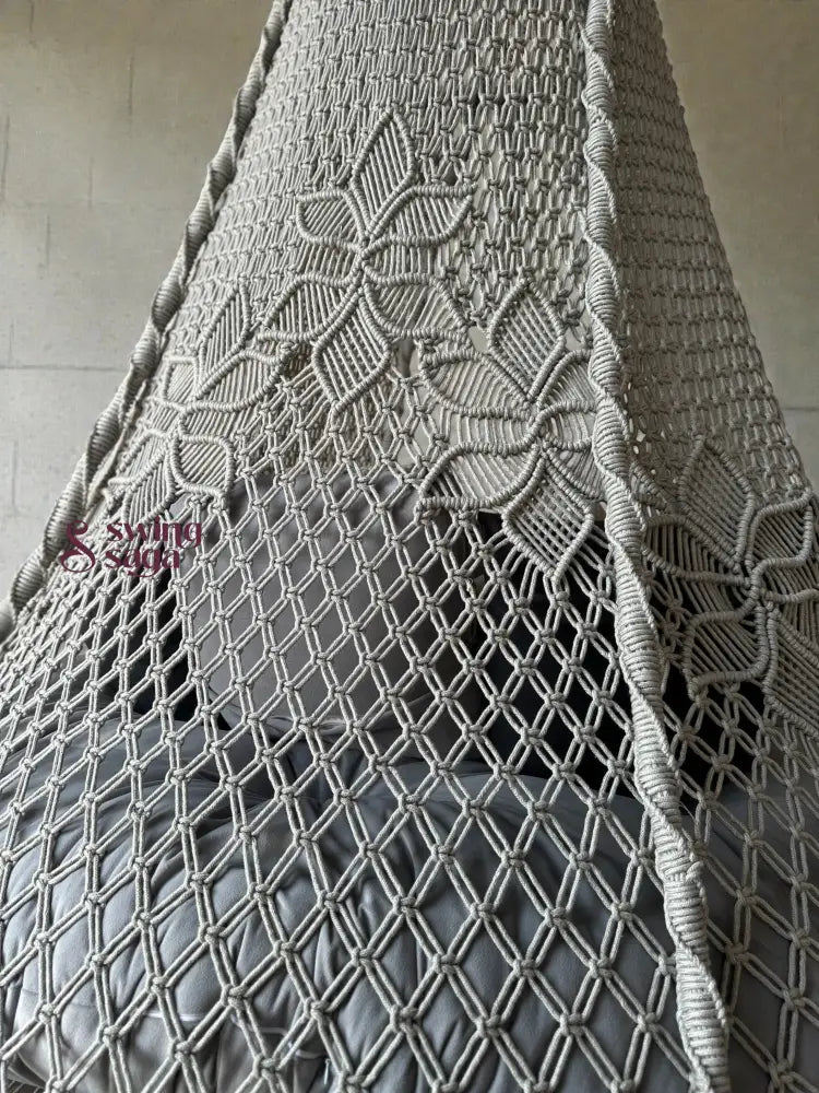 Intricate macrame knotting design on the Back of a grey macrame swing.