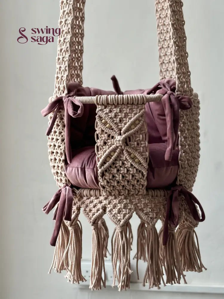 Macrame baby swing handcrafted in baby pink color with tassels on the bottom.