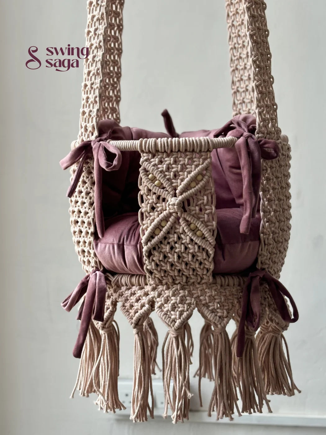 Macrame baby swing handcrafted in baby pink color with tassels on the bottom.