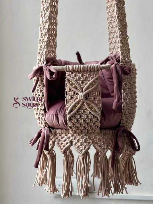 Macrame baby swing handcrafted in baby pink color with tassels on the bottom.