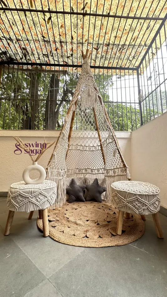 Small white macrame teepee with a pair of ottomans in white.