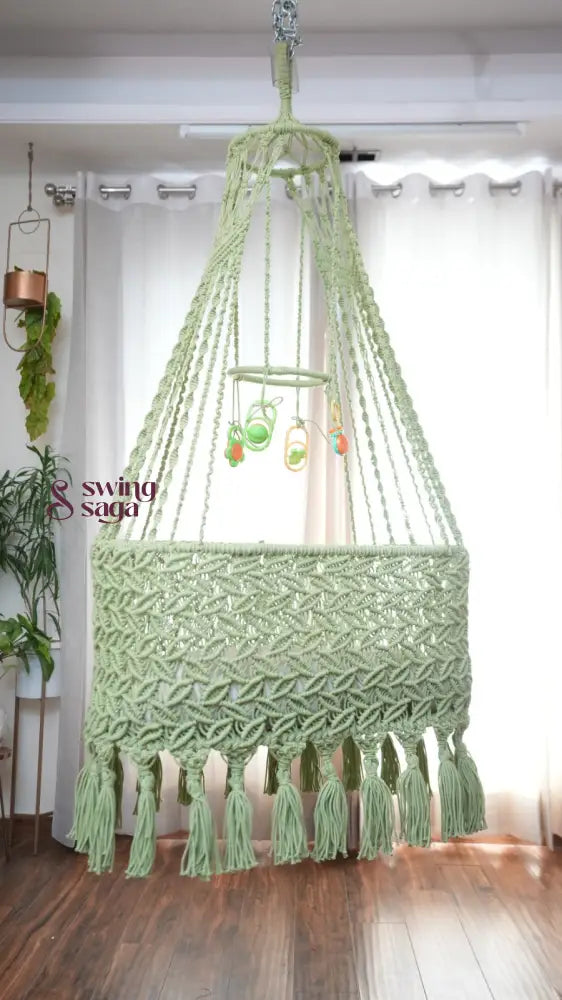 A lime green colored macrame baby cradle in a nursery room.
