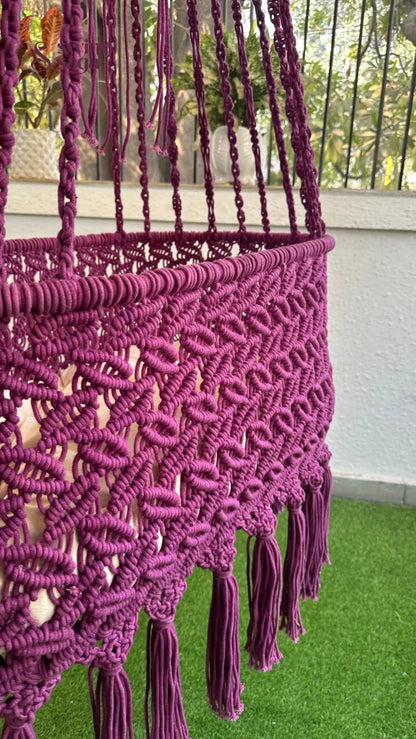 Detailed image of handcrafted macrame swing in purple color. 