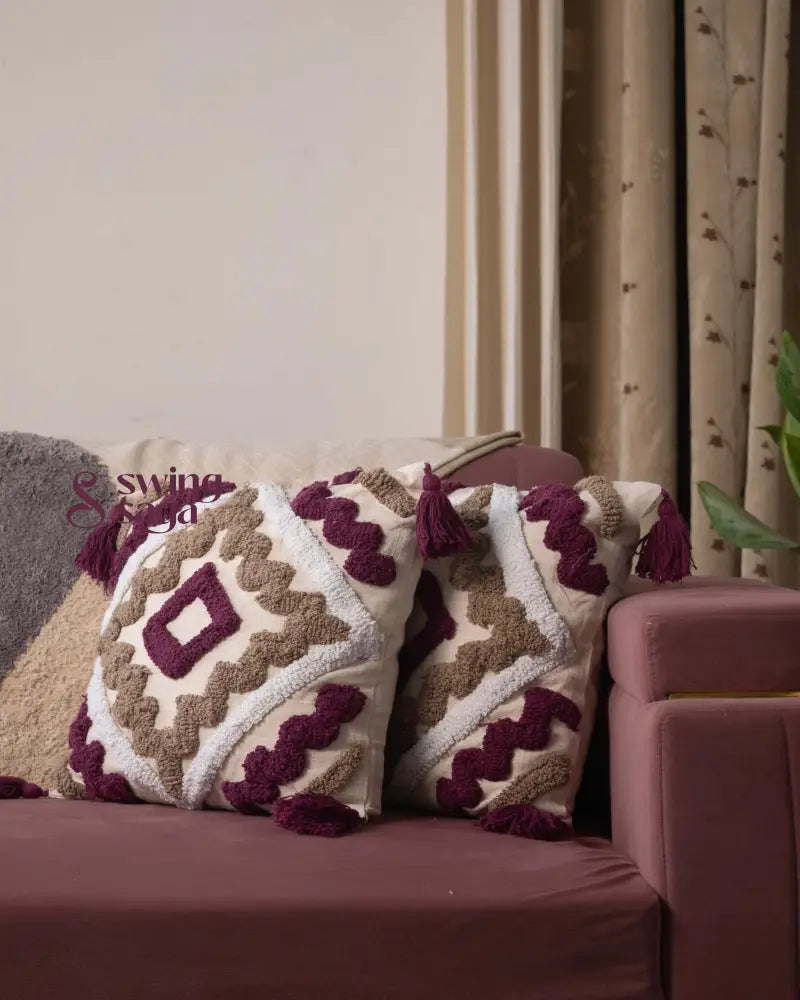 Decorative pillows with geometric patterns on a sofa against a neutral wall.