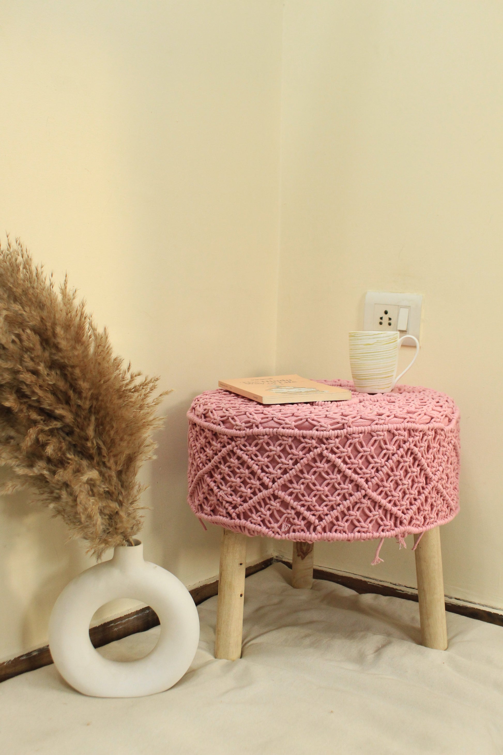 Handcrafted pink macrame ottoman with wooden legs