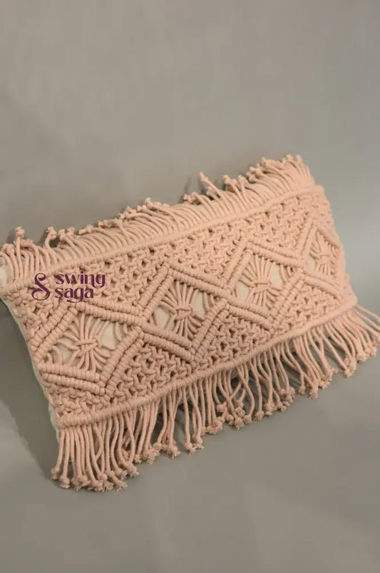 Pink macrame clutch bag with fringes on a gray background