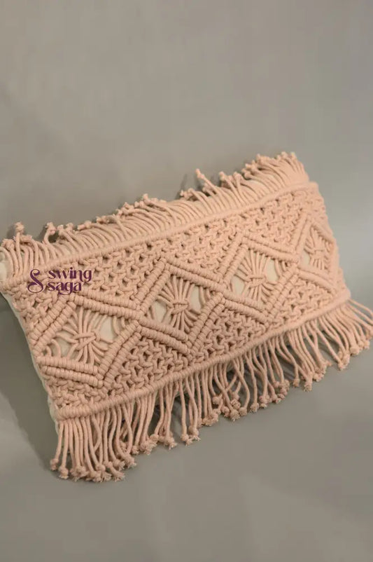 Pink macrame clutch bag with fringes on a gray background