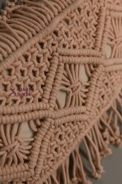 Close-up of a beige macrame wall hanging with intricate patterns and fringes.