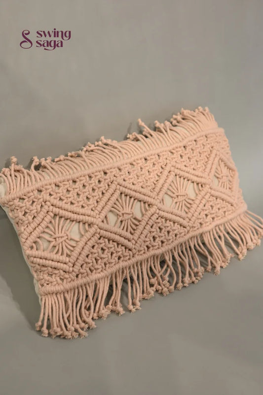 Pink macrame clutch bag with fringes on a gray background