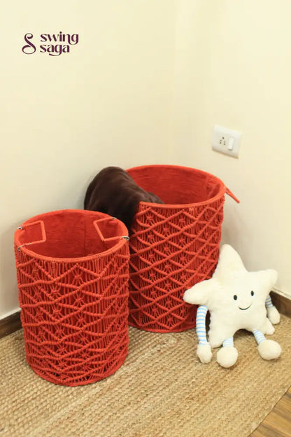 Pair of red handcrated macrame laundry baskets with a smiley face star cushion.