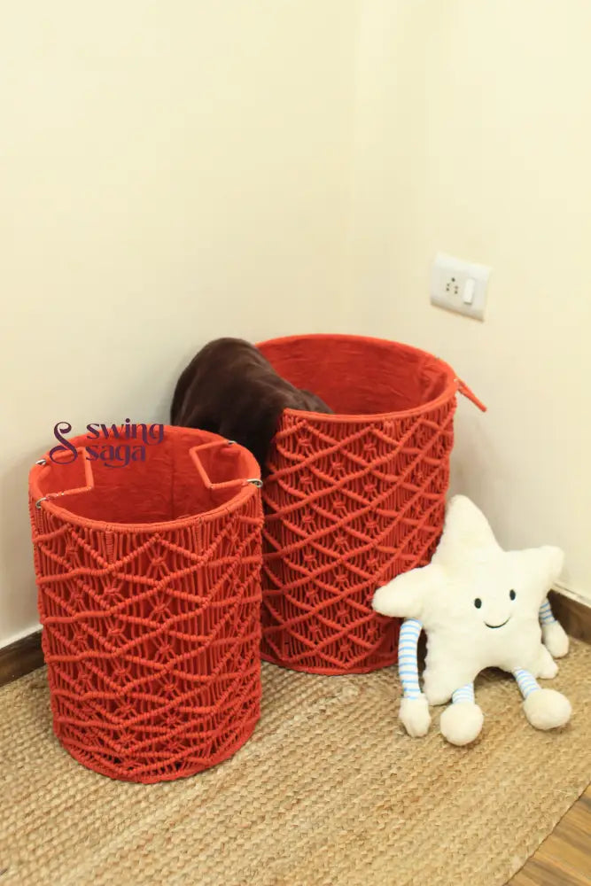 Pair of red handcrated macrame laundry baskets with a smiley face star cushion.