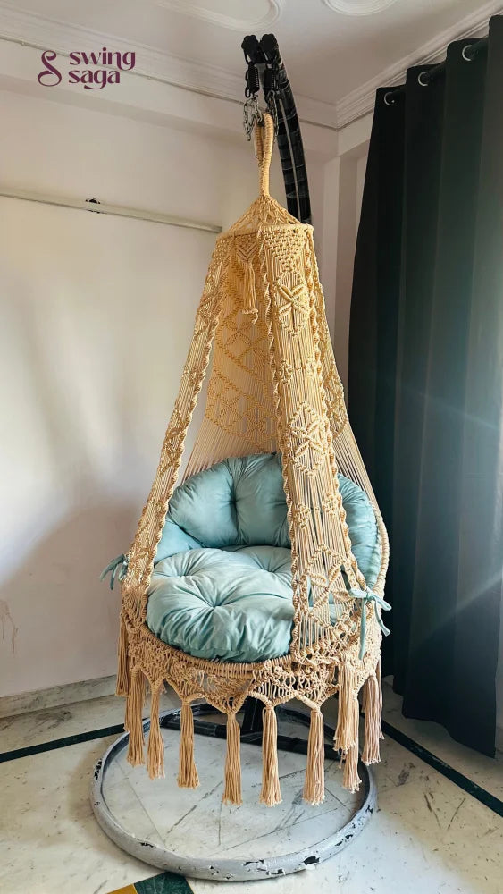 indoor chair swing with a black metal stand.