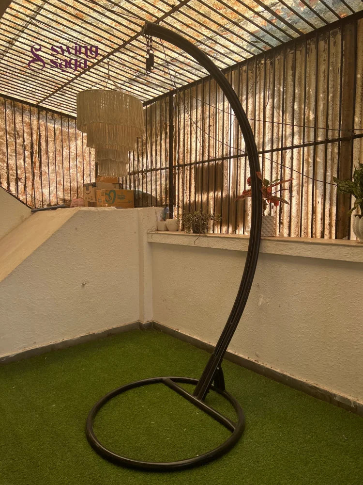 black metal stand with curved arm on a faux grass mat.