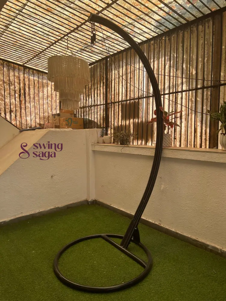 black metal stand with curved arm on a faux grass mat.