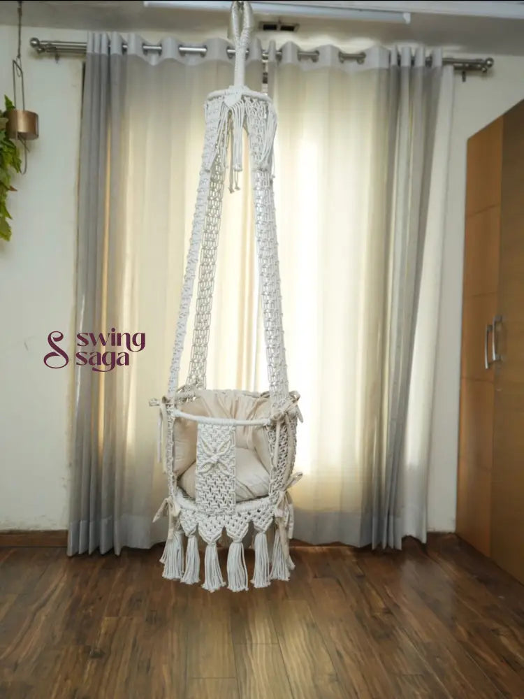 Hanging white baby swing in a room setting.