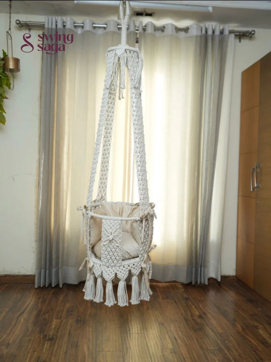 Hanging white baby swing in a room setting.