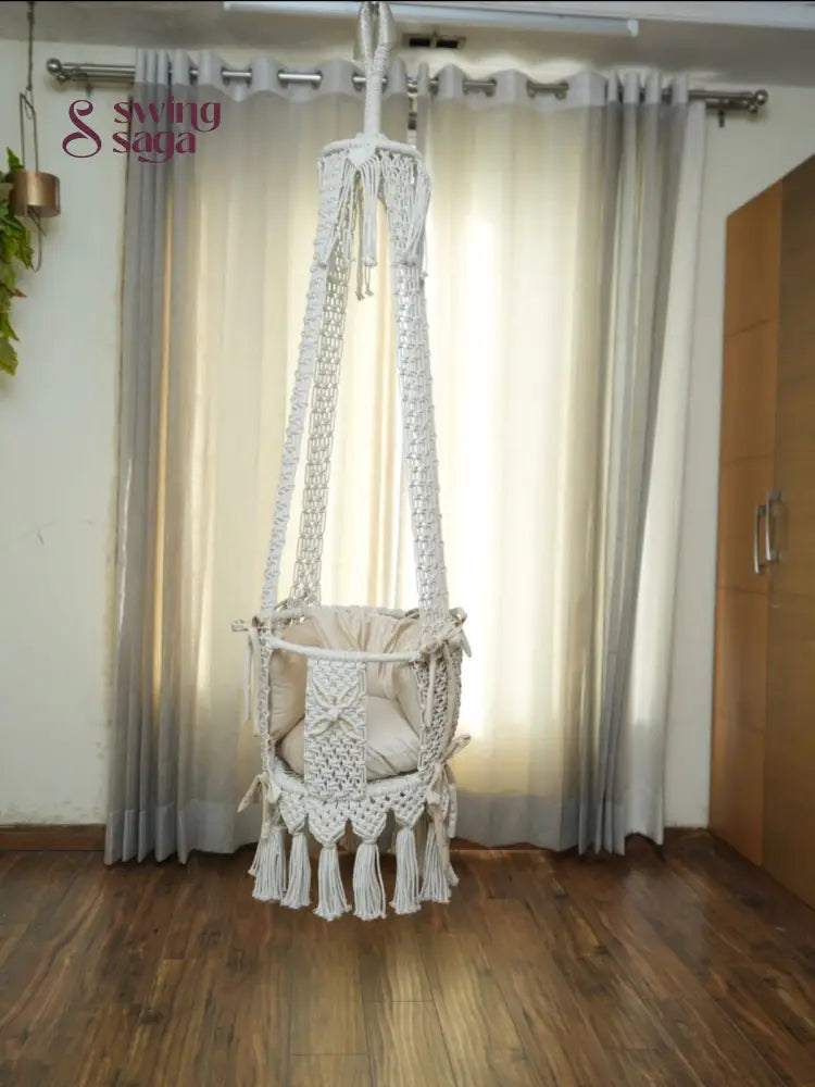 Hanging white baby swing in a room setting.
