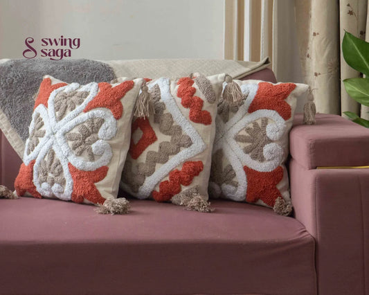 3 pair of cushions on a sofa agiant a neutral wall.