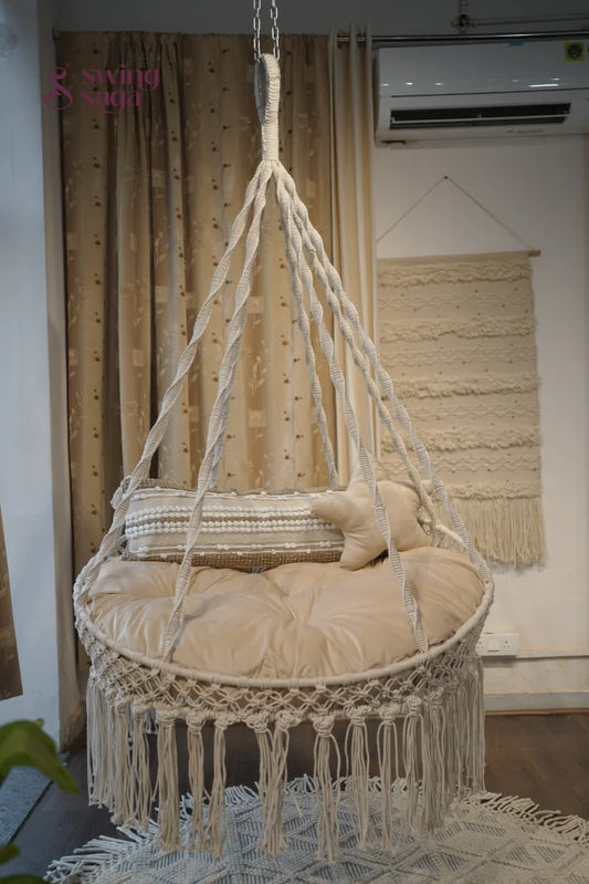 cream porch hanging swing with a rectangle cushion and a  star cushion.