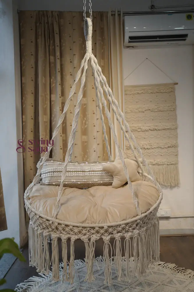 cream porch hanging swing with a rectangle cushion and a  star cushion.