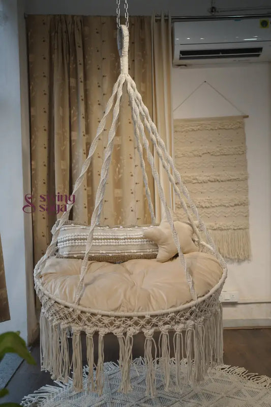 cream porch hanging swing with a rectangle cushion and a  star cushion.
