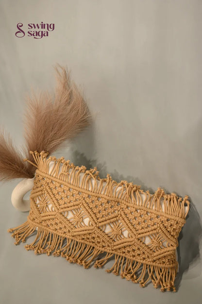 Macrame clutch with fringes and feathers on a neutral background
