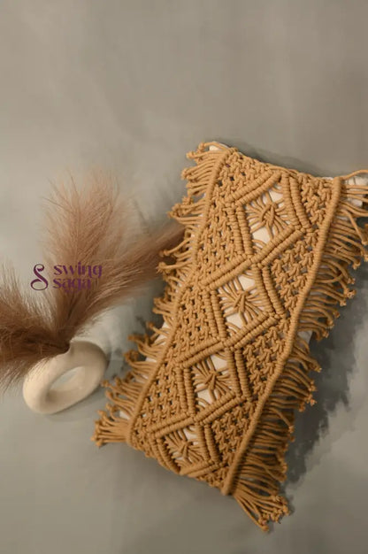Macrame wall hanging with geometric pattern and fringes on a neutral background