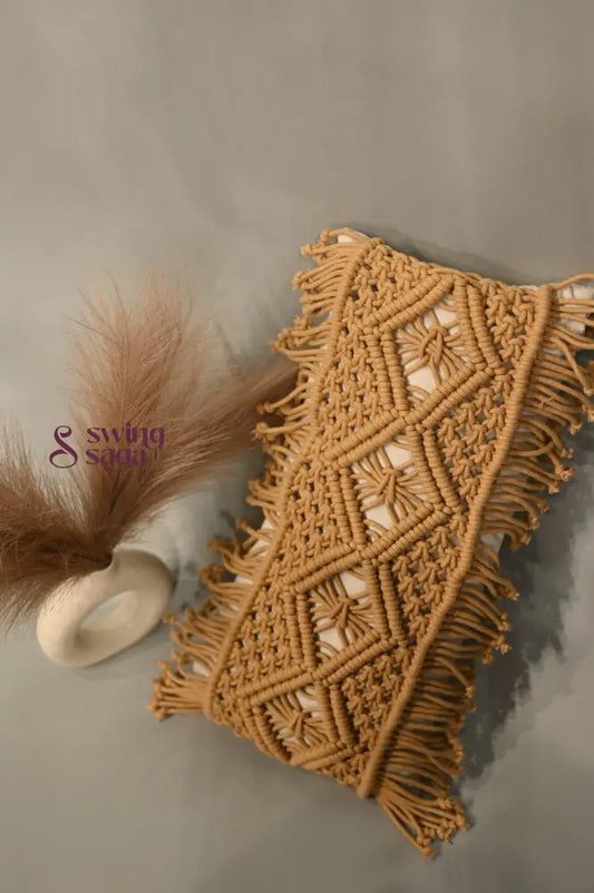 Macrame wall hanging with geometric pattern and fringes on a neutral background