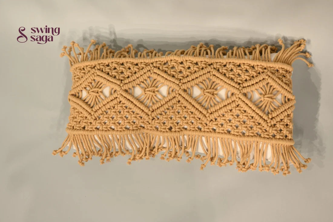 Decorative macrame wall hanging with geometric pattern and fringes on a plain background