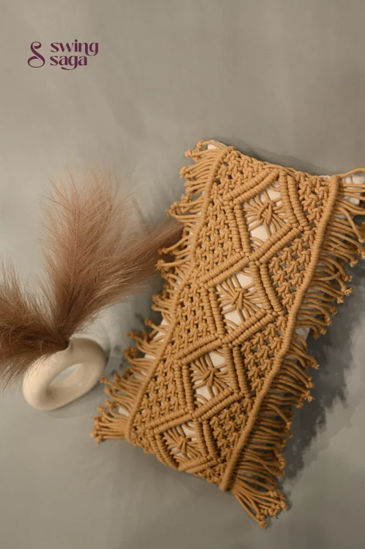 Macrame wall hanging with geometric pattern and fringes on a neutral background