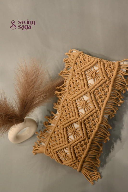Macrame wall hanging with geometric pattern and fringes on a neutral background