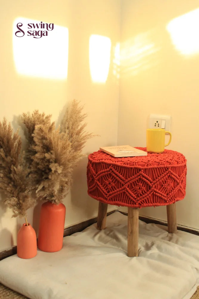 Orange Macrame Ottoman with yellow coffee mug and terracotta vase.