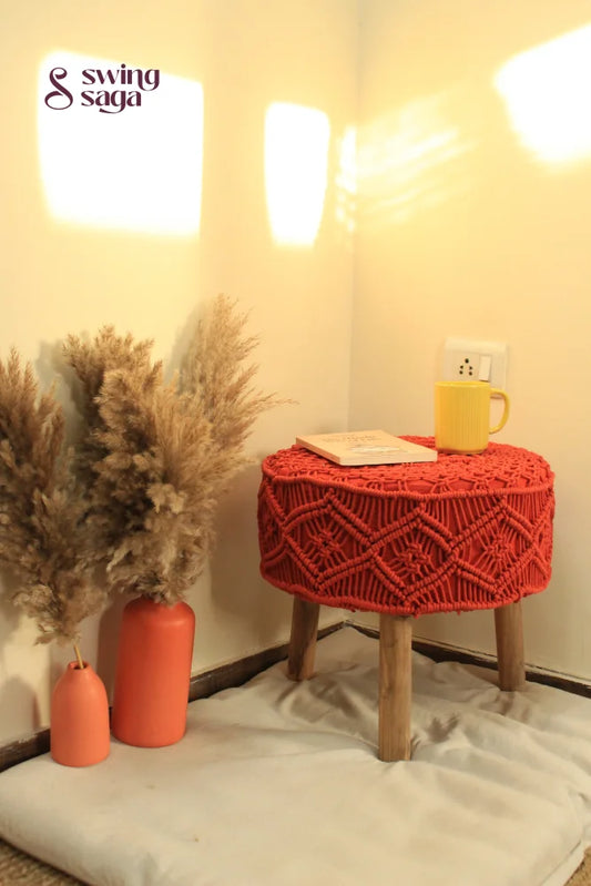 Orange Macrame Ottoman with yellow coffee mug and terracotta vase.
