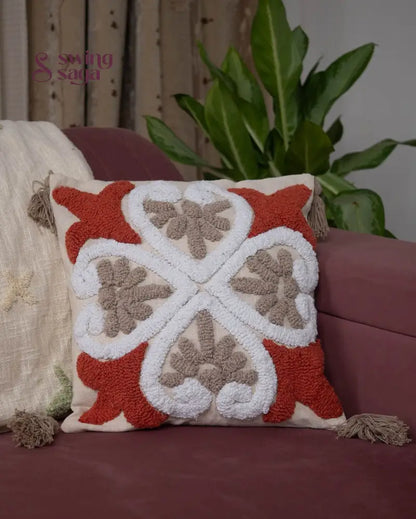 Square shaped cushion in orange and white color.