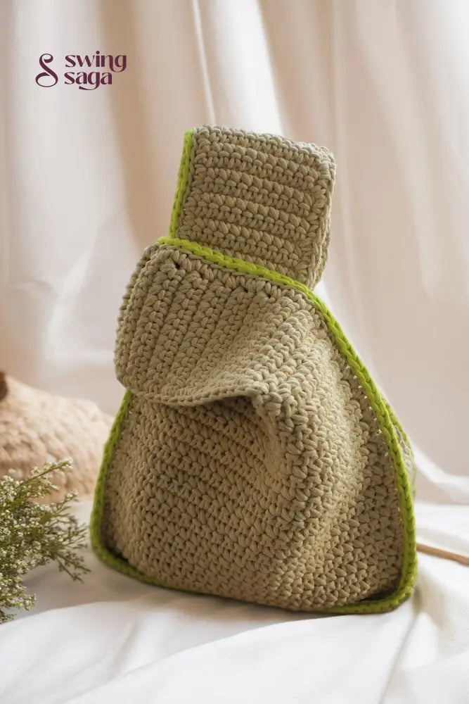 Handcrafted beige crochet handbag with green lining on the corner for everyday use.