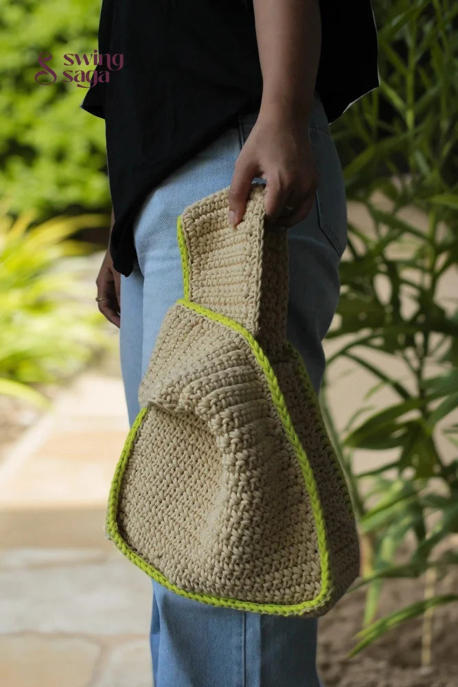 A girl holding a beige color bag with green border for casual outings.