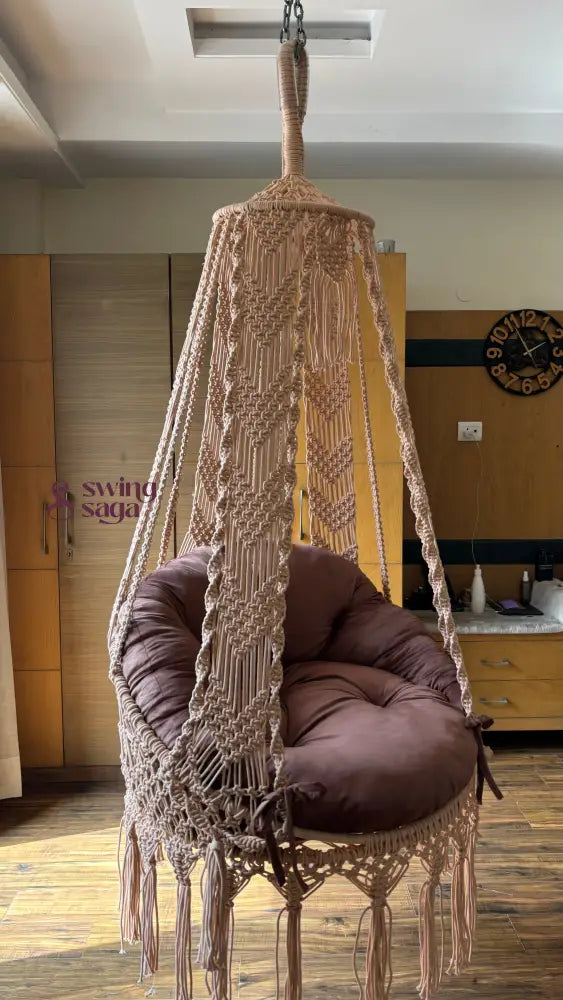 Hanging hammock swing with brown mattress and cushion in a room sertting.