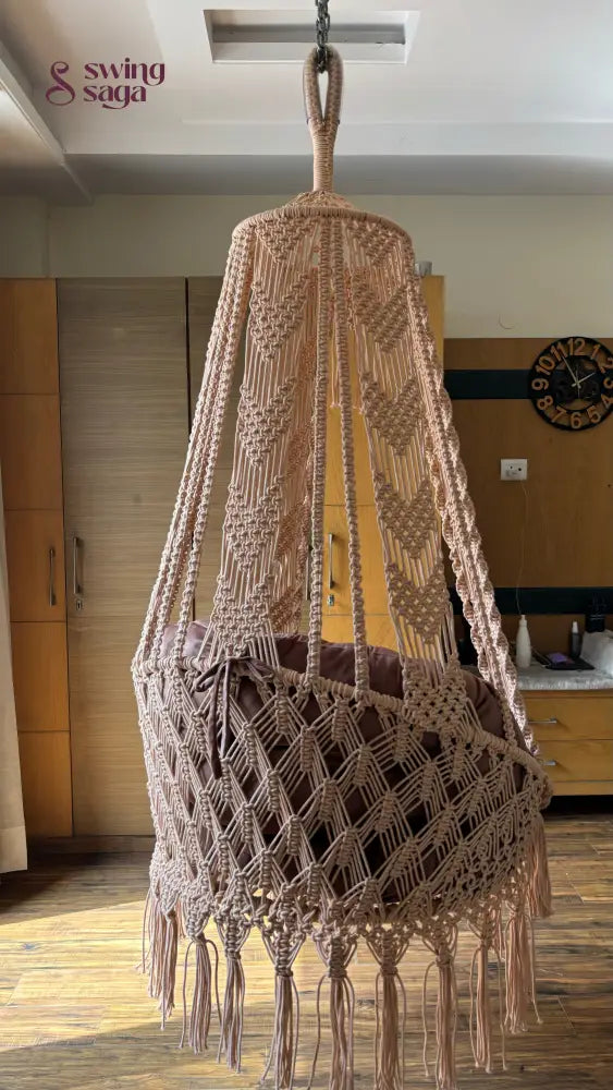 Hanging hammock swing chair in brown color with mattress and cushion.