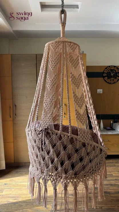 Hanging hammock swing chair in brown color with mattress and cushion.