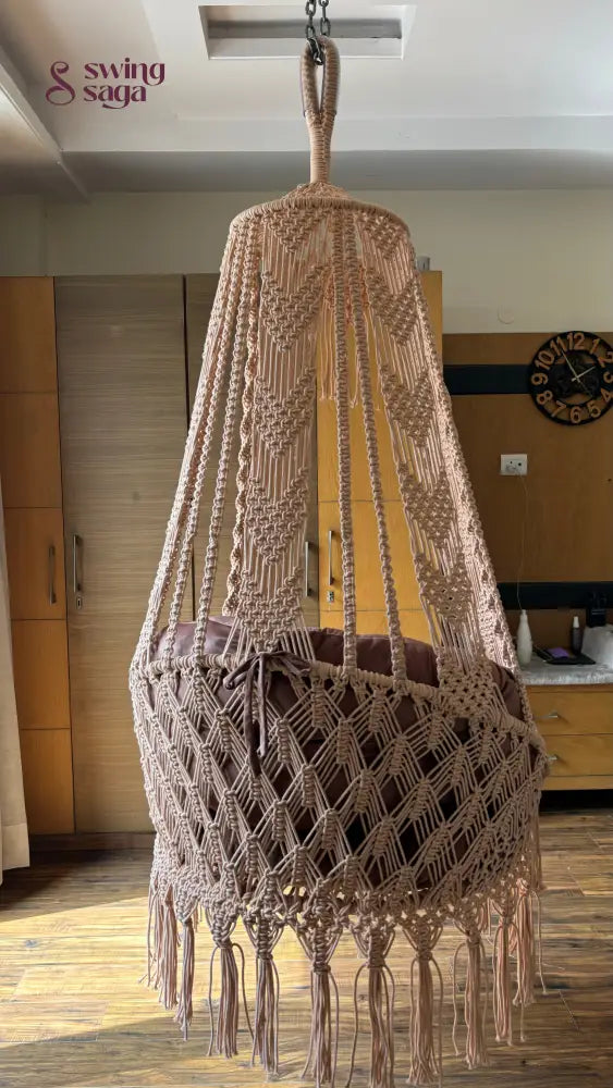 Hanging hammock swing chair in brown color with mattress and cushion.