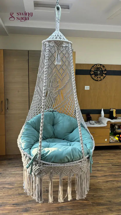 White chair hammock swing hanging in a wooden flooring room.