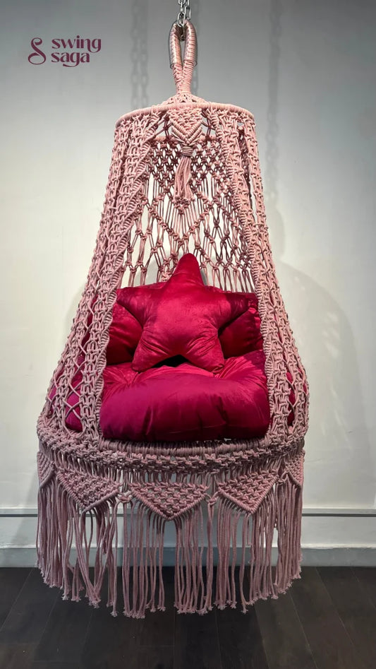 Pink macrame hanging swing for toddlers.