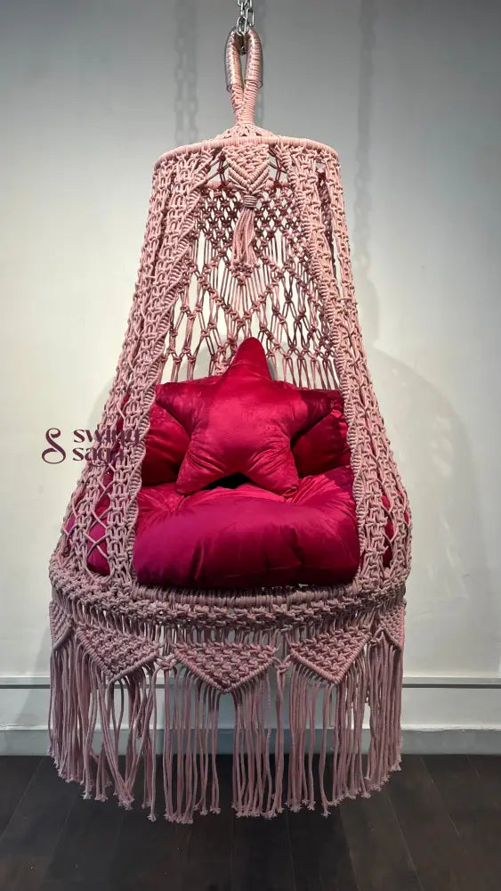 Pink macrame hanging swing for toddlers.
