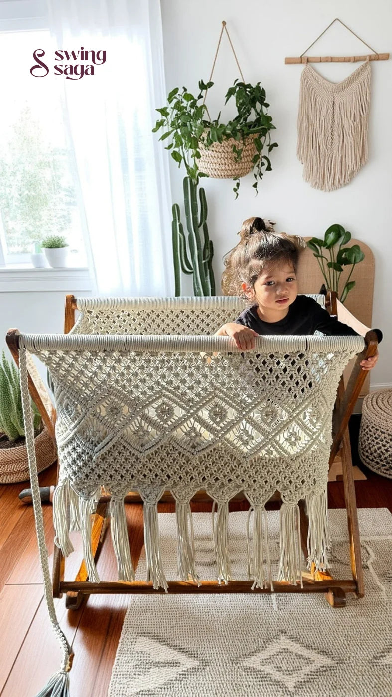Child playing in a white macrame bassinet in a bright room with plants.