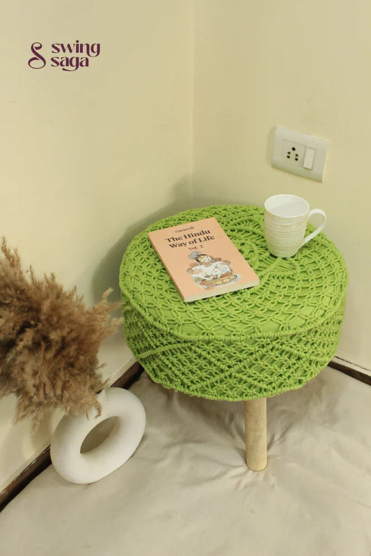 Stylish green macrame pouf with handcrafted texture and durable wooden legs.